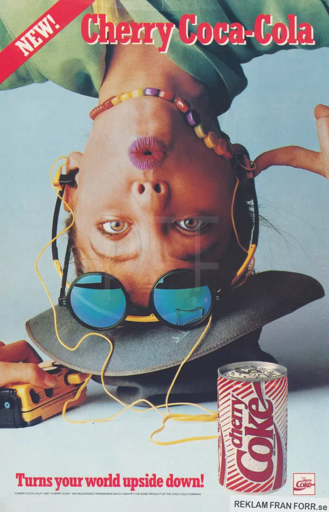 Reklam för läskedrycken Cherry Coke med en person som står på huvudet och ser glad ut