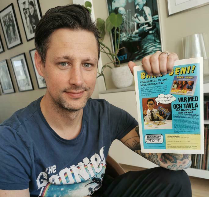 En vuxen Ted Kideborn med Kalle Anka-tidningen med annonsen för Barn-Geni!